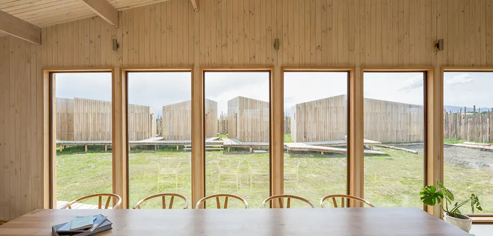 AKA Patagonia, módulo principal, madeira lenga, interior, mesa, janelas vidro