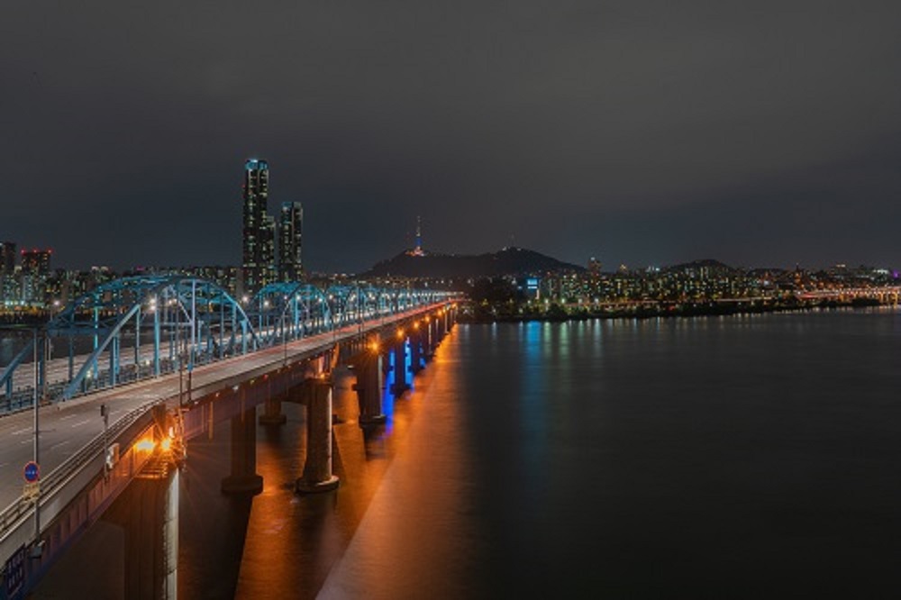 Seul, ponte sobre o Rio Han, ao fundo a cidade iluminada a noite.