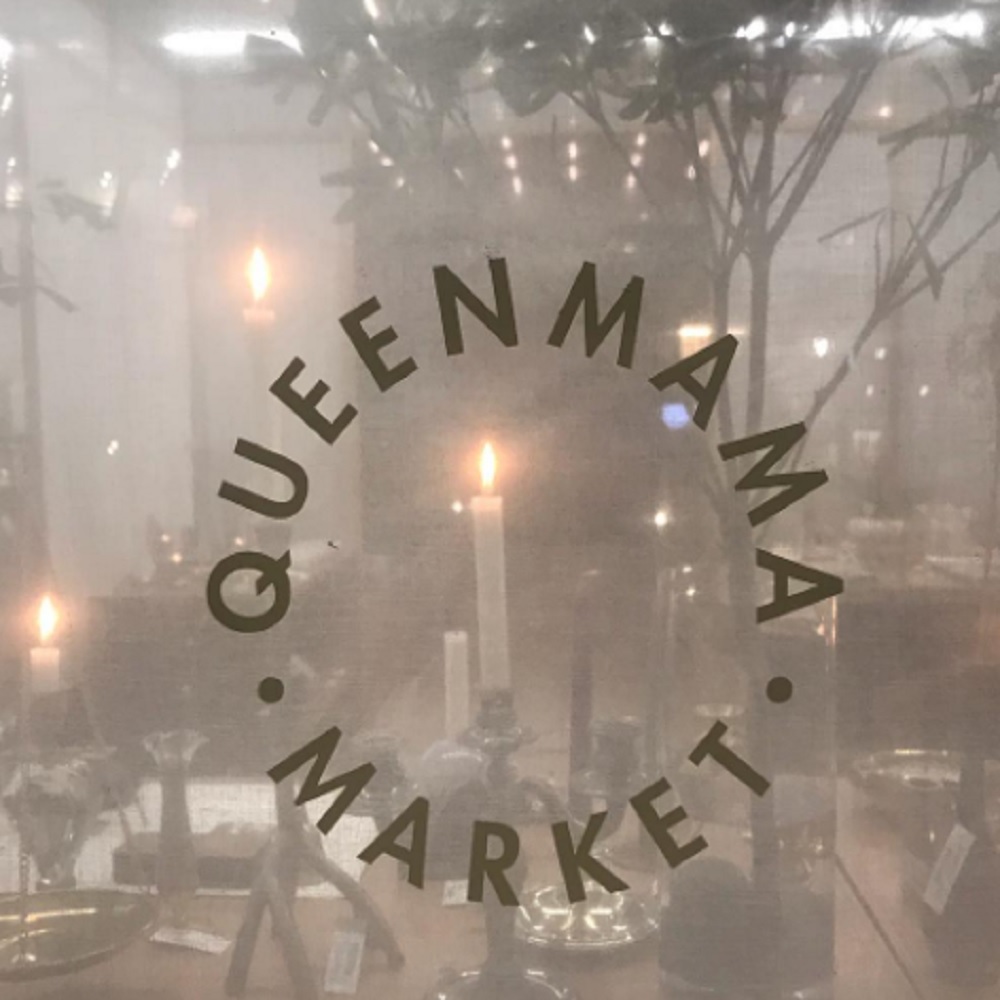 Janela com o letreiro arredondado escrito Queen Mama Market.