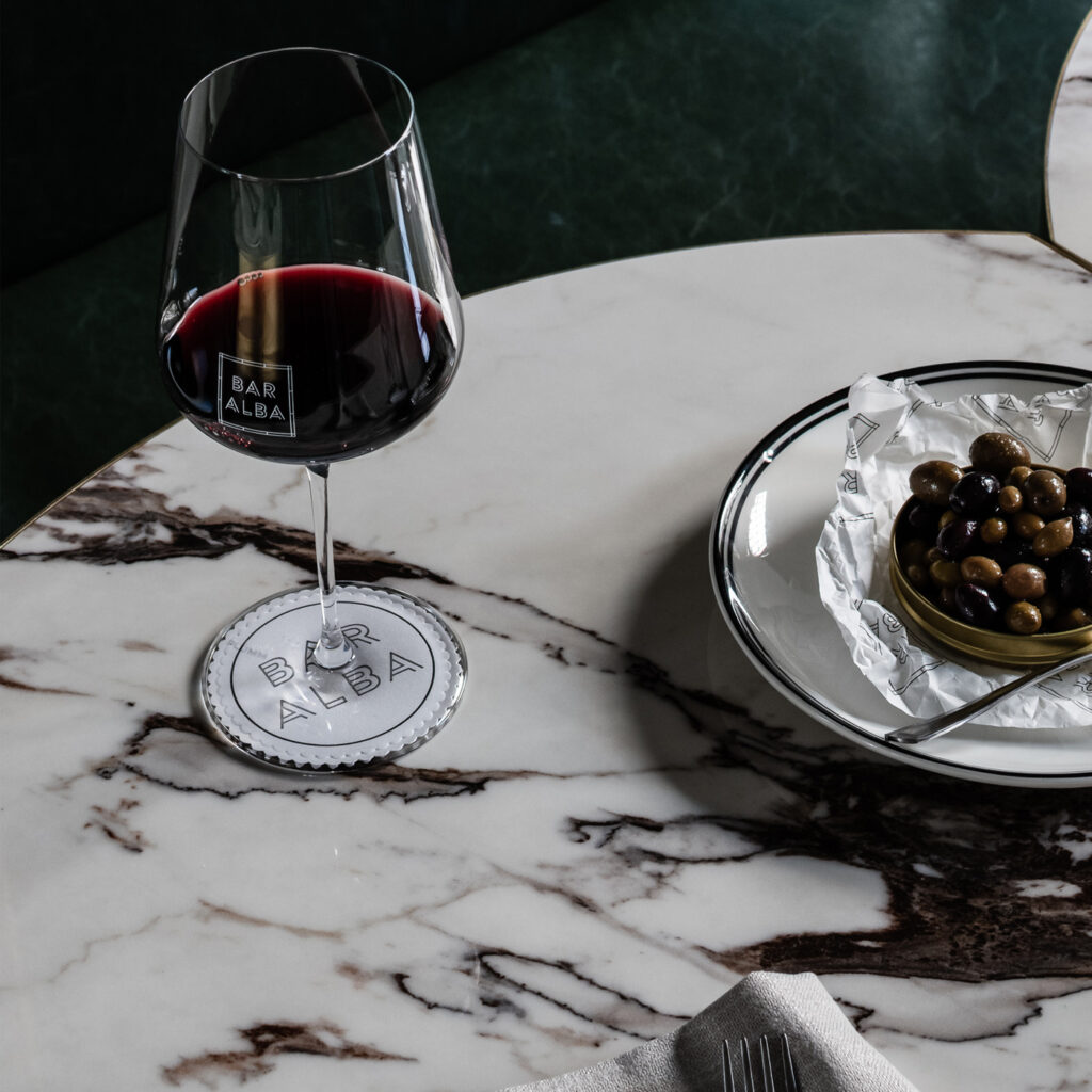 Taça de vinho e prato com azeitonas 