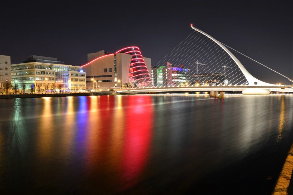 Rio Liffey a noite, com a ponte Samuel Beckett Bridge ao fundo, juntamente com o The Convention Centre Dublin.