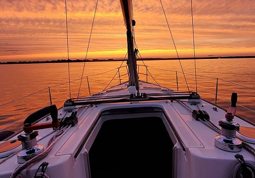 Barco navegando ao pôr do sol.
