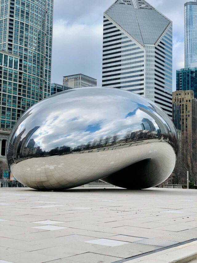 Instalação Cloud Gate, no Millennium Park de Chicago. Foto de Anish Kappor. Na imagem uma escultura de nuvem prateada instalada em meio ao pavimento do parque