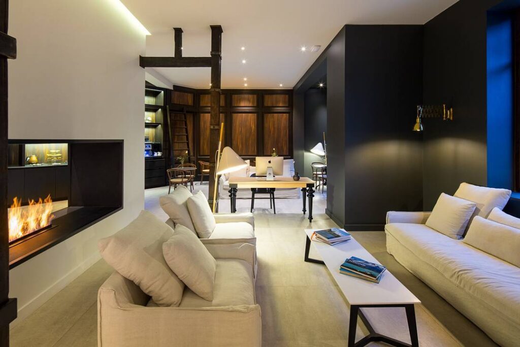 hotéis boutique de Santiago:: sala elegante com sofás brancos, lareira e design moderno-industrial, ideal para hospedagem sofisticada