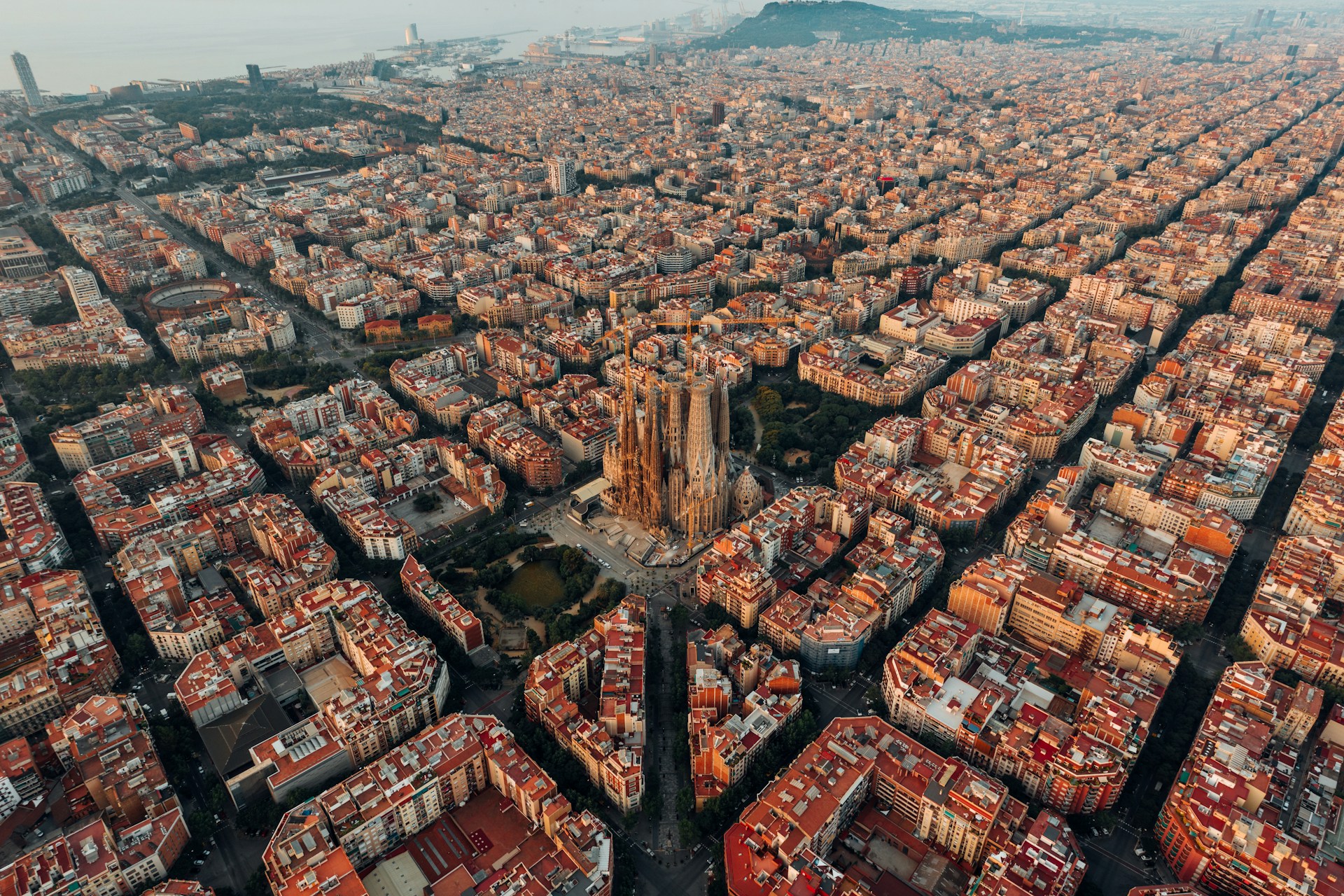 vista de cima da cidade de Barcelona, mostrando a sagrada família e os quarteróes que formam pátios internos