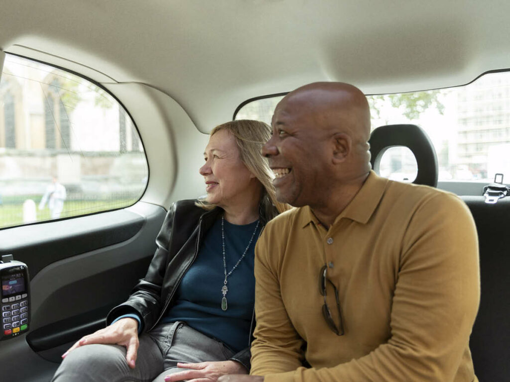 Casal dentro de um carro utilizado para serviço de transfer / traslado