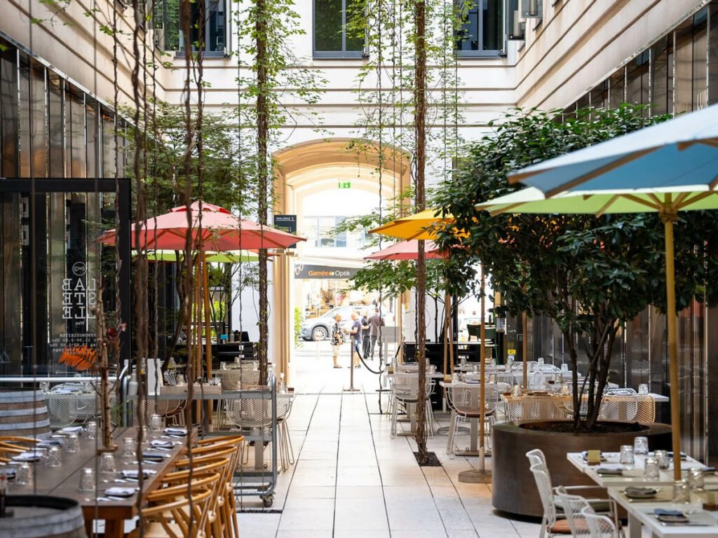 Área externa do restaurante Labstelle, um dos melhores de Viena, cruzando duas ruas vienenses em um espaço com jardim suspenso