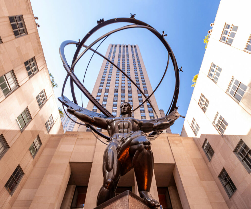 Prédio do complexo Rockefeller Center com uma estátua de um homem na frente