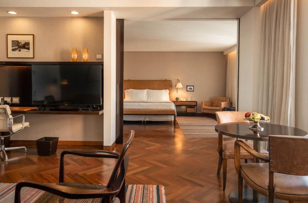 Imagem mostra um dos quartos do hotel Fasano nos Jardins. O local é bem iluminado com móveis minimalistas clássicos em madeira. Hotéis em São Paulo.