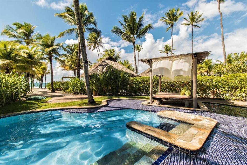 Visão de praia ao fundo de uma bela piscina instalada no Resort Nannai Muro Alto, resort de luxo no nordeste