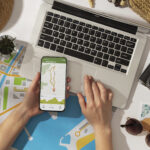 Google maps para viagens- pessoa usando o computador e o celular simultaneamente