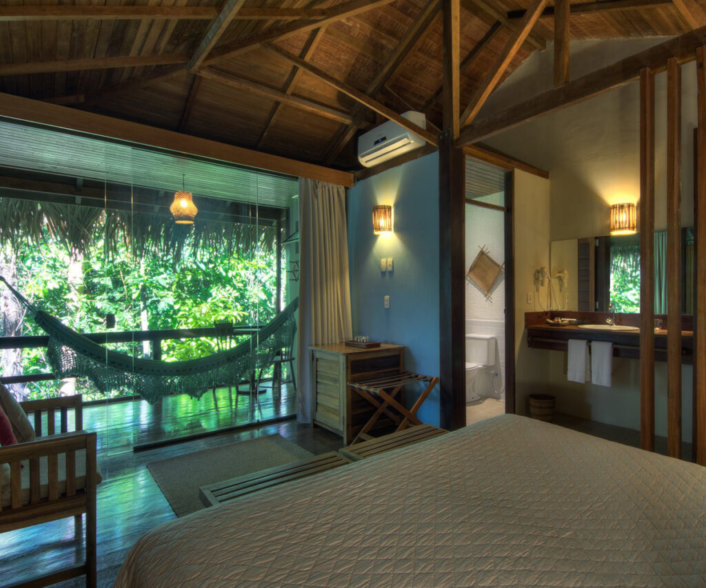 Acomodação do Anavilhanas Jungle Lodge com varanda, banheiro e vista para a floresta