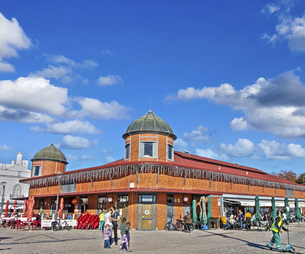 Fachada do mercado municipal de olhão com pessoas na frente, pequena cidade de Portugal