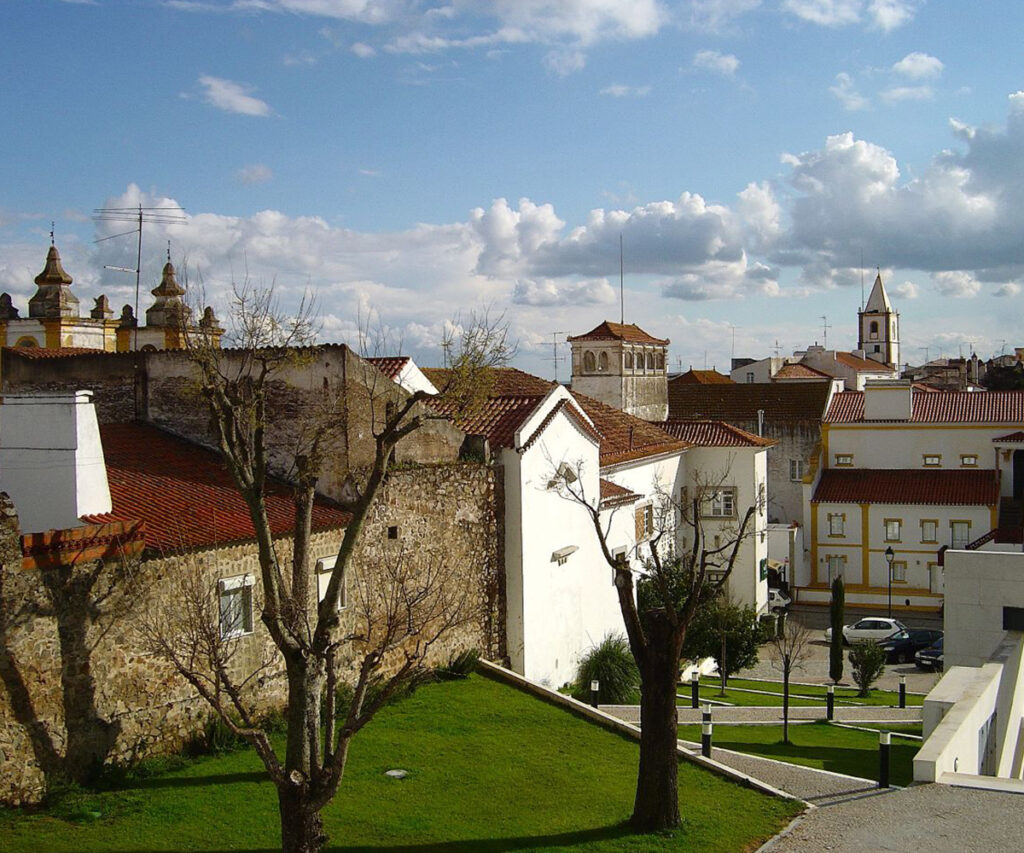 Área central da cidade pequena de Portugal de Monforte. Praça com árvores e casas.
