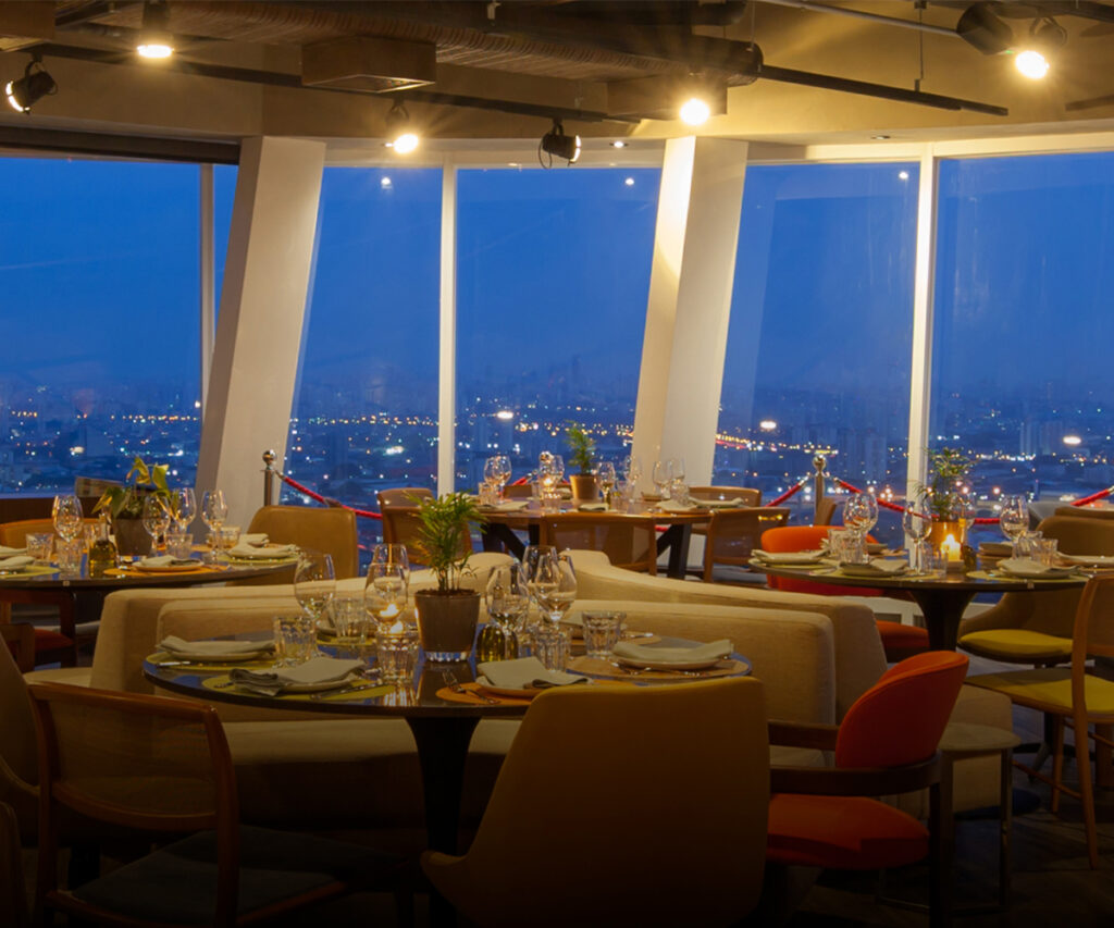 área de jantar do lassu rooftop com vista para a cidade