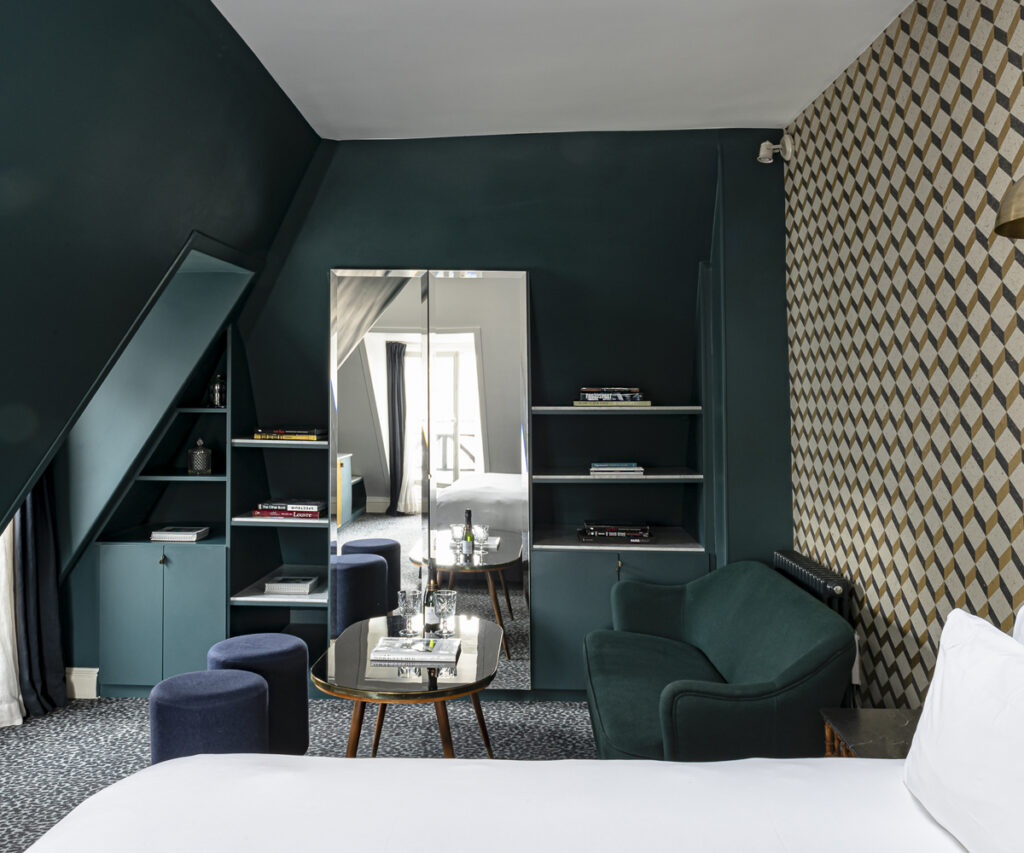 quarto do grand pigalle, um dos melhores hotéis para famílias em Paris - cama com sofá e puffs
