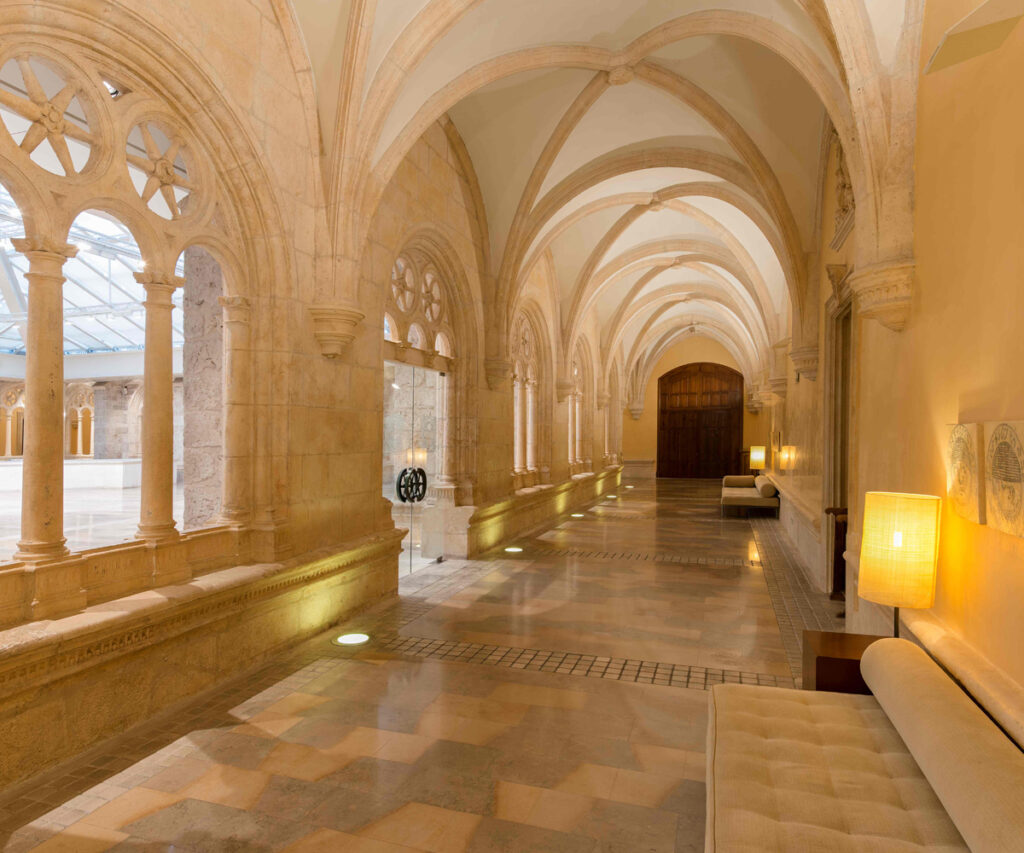 corredor interno do nh collection, um dos paradores da Espanha, com vista para a sala de recepção. espaço com colunas e tetos abobadados