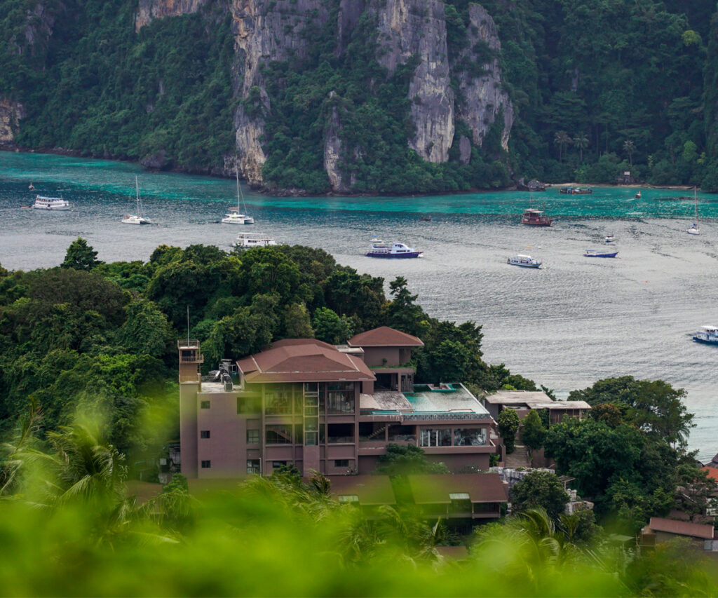 Paisagem das ilhas phi phi - construção rodeada por mata e mar ao fundo