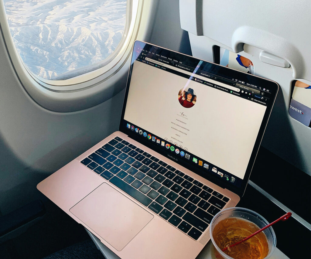 pessoa usando o computador no avião para fazer roteiro de viagem
