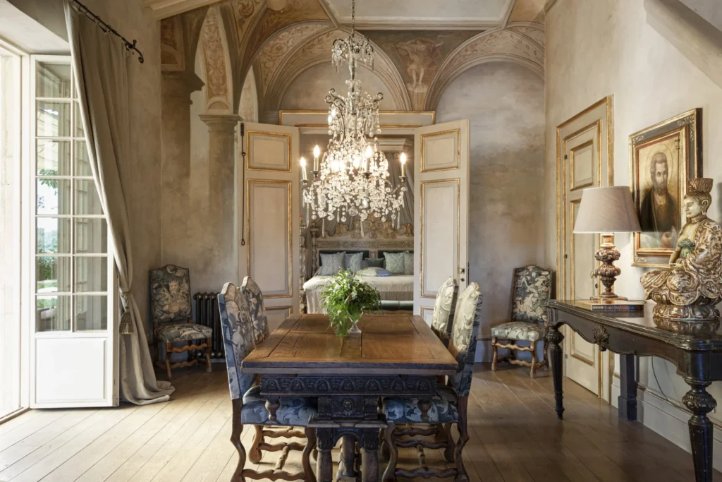Quarto de hotel de luxo na Toscana com decoração clássica, móveis antigos e lustre