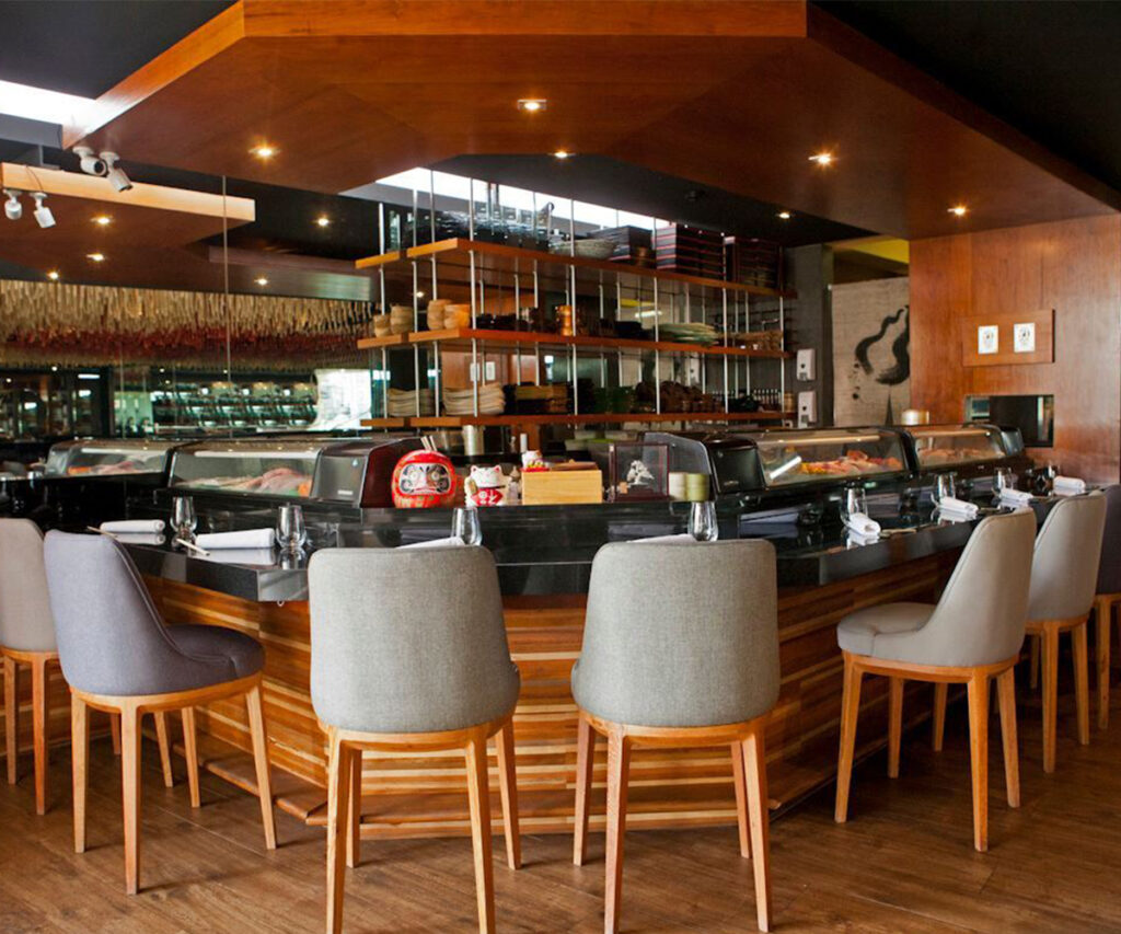 Restaurante moderno com decoração de interiores brasileira, móveis de madeira e iluminação elegante.