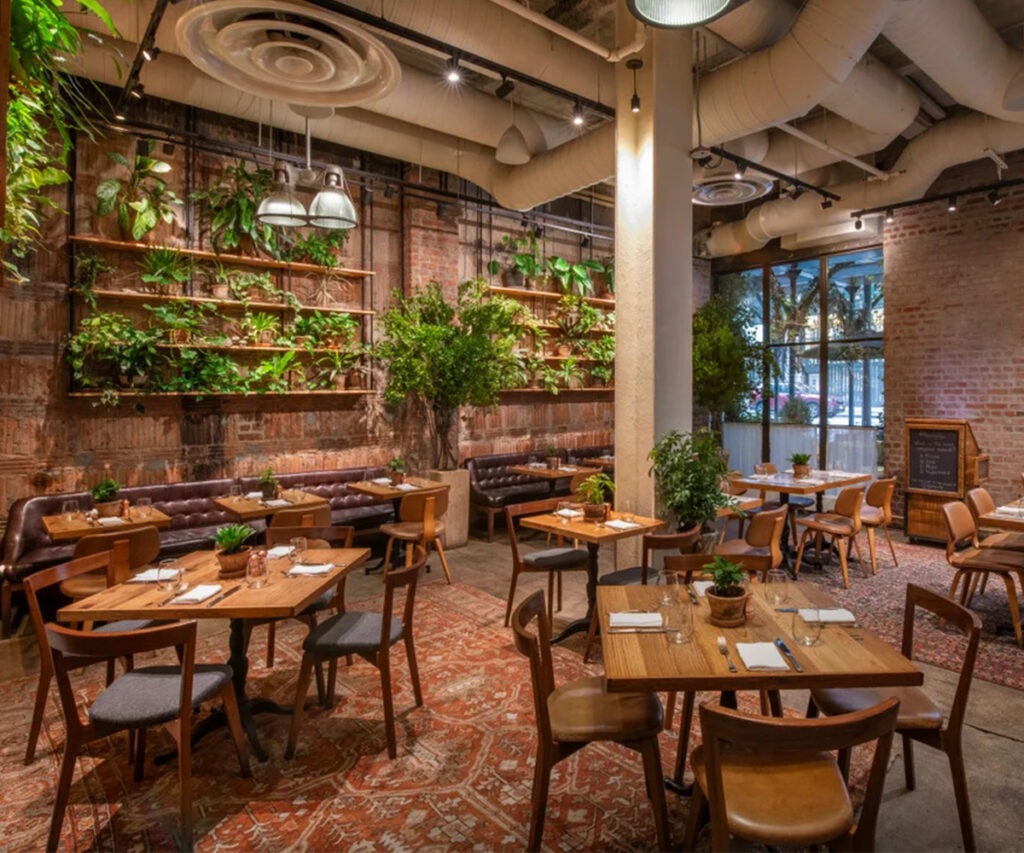 Restaurante moderno com decoração industrial e vegetação no 1 Hotel Central Park