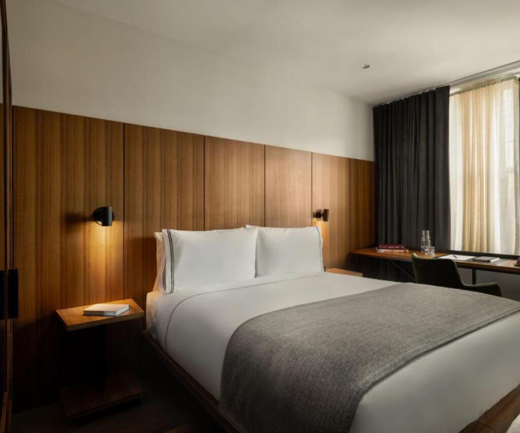 Melhores hotéis de Nova York: quarto moderno com cama branca e lençóis cinza. Hotel The Moore NY