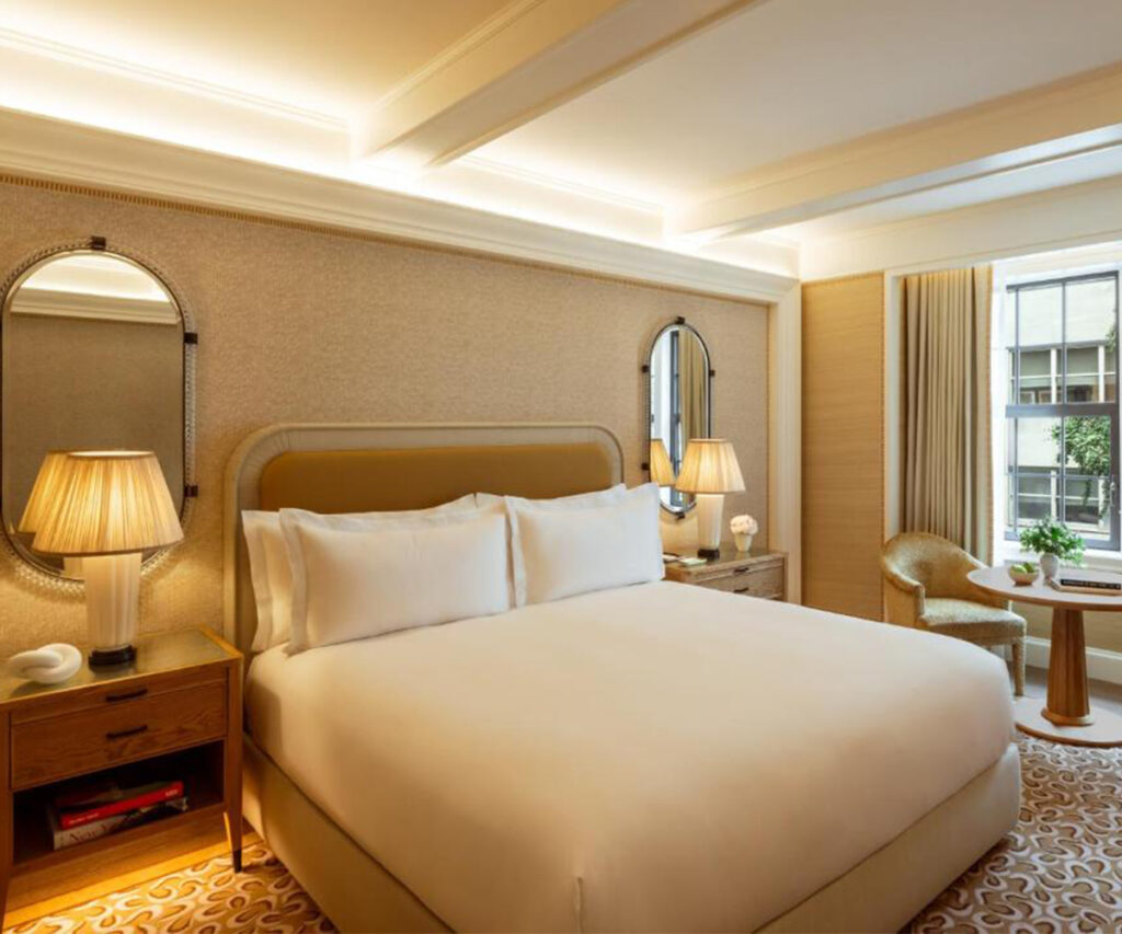Quarto de hotel luxuoso no The Surrey com cama branca e decoração moderna