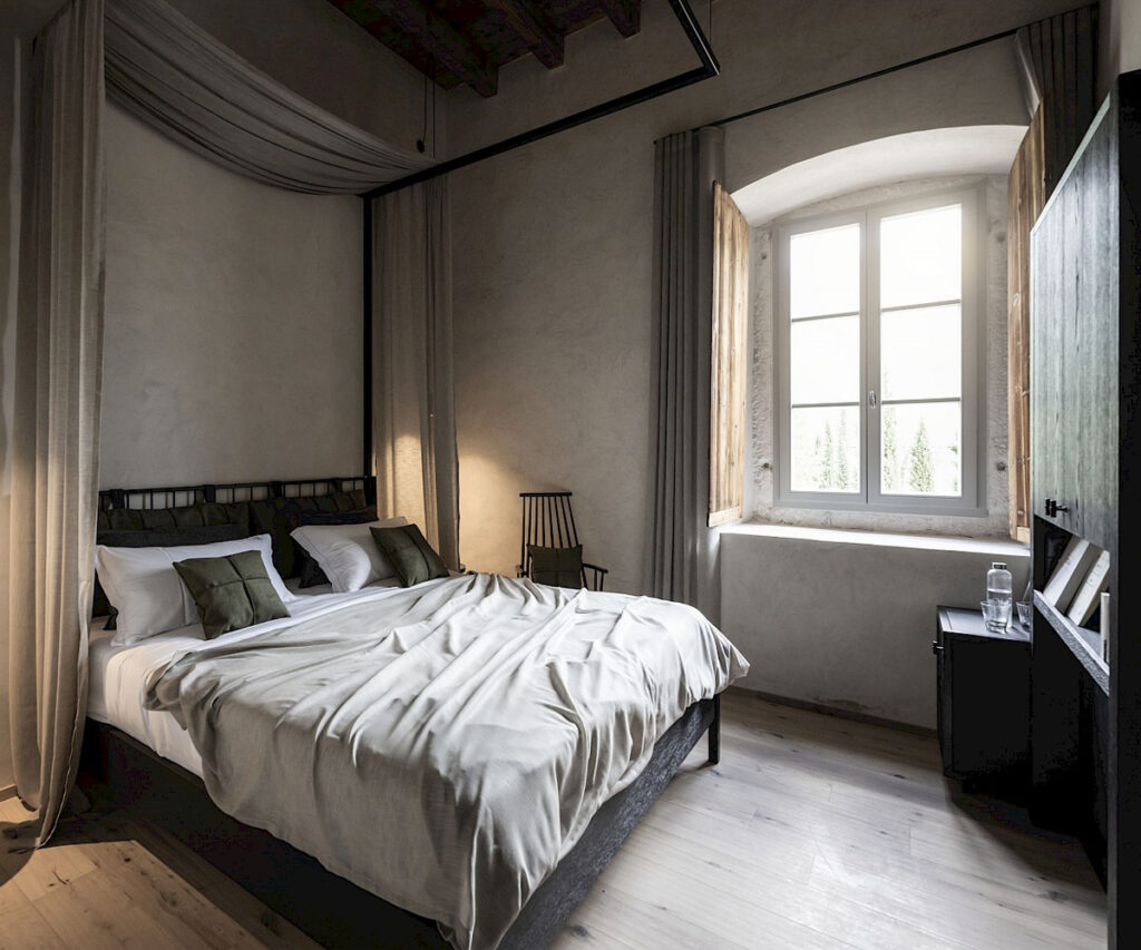 Quarto de hotel luxuoso no Monastero Arx Vivendi com decoração minimalista e elementos históricos