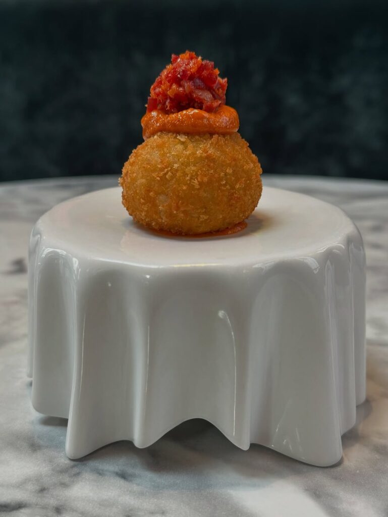 Croqueta de matanza ibérica em prato branco no Restaurante Maché em Madrid