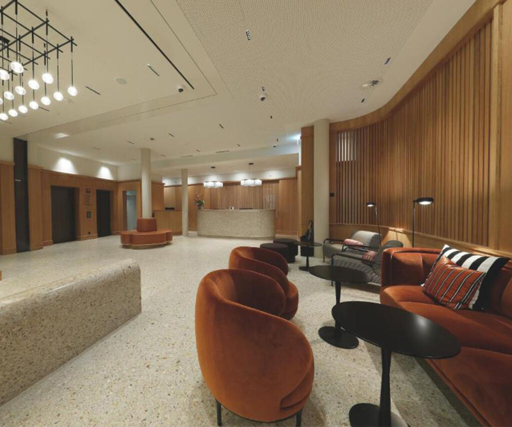 Onde ficar em Berna: lobby moderno com poltronas laranjas e painéis de madeira.