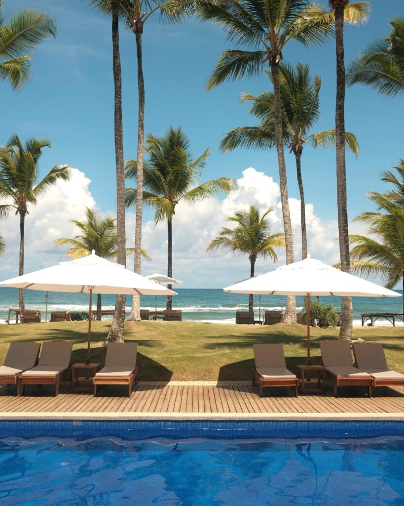 Resorts no nordeste: Txai Resort em Itacaré, BA, com piscina, espreguiçadeiras e palmeiras.