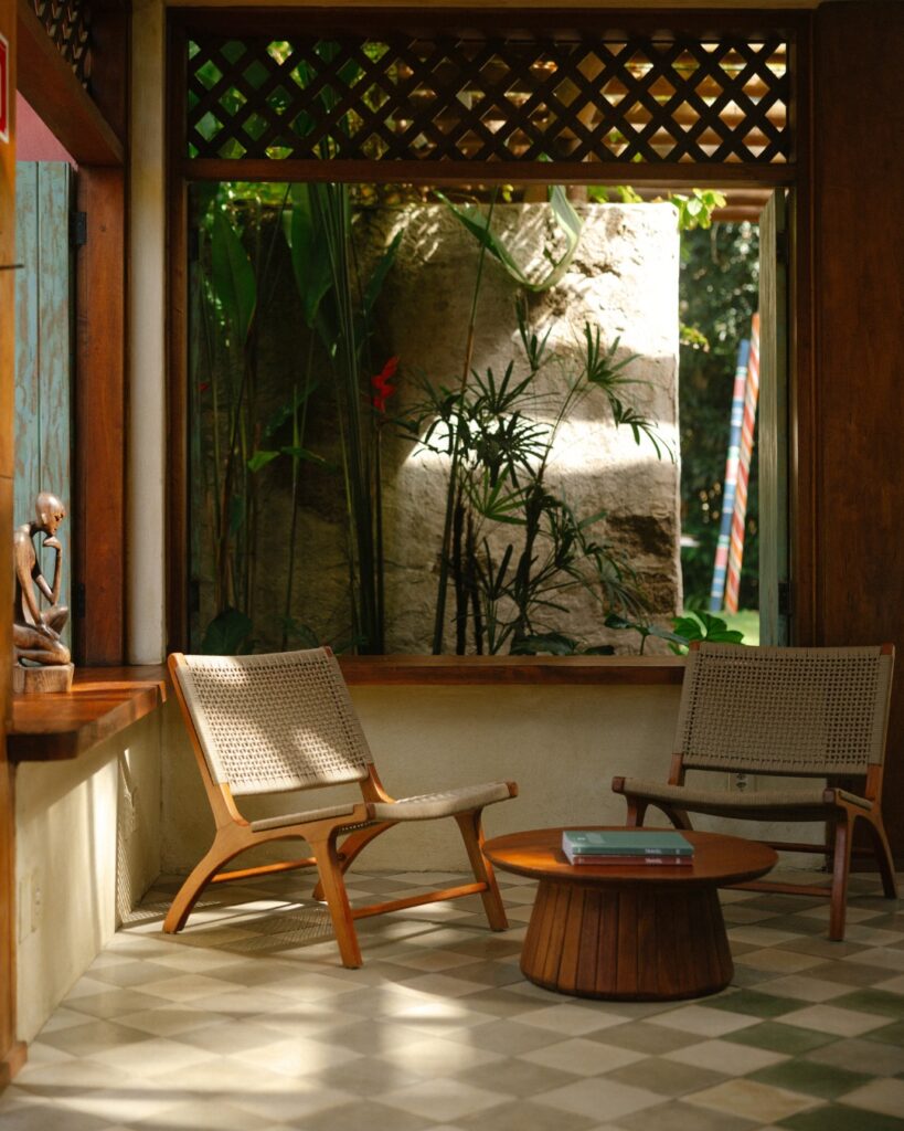 Resorts no nordeste: área de estar no Txai Resort em Itacaré, BA, com móveis de madeira e plantas tropicais.