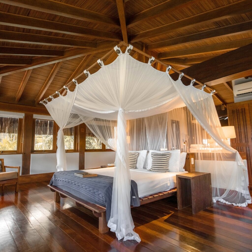 Resorts no nordeste: Txai Resort em Itacaré, BA, com quarto luxuoso e cama com mosquiteiro.