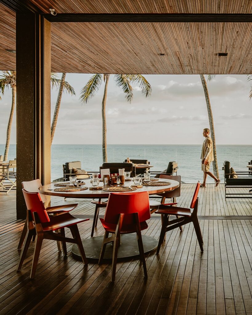 Área de jantar moderna no Carmel Taíba, São Gonçalo do Amarante, com vista para a praia e palmeiras.