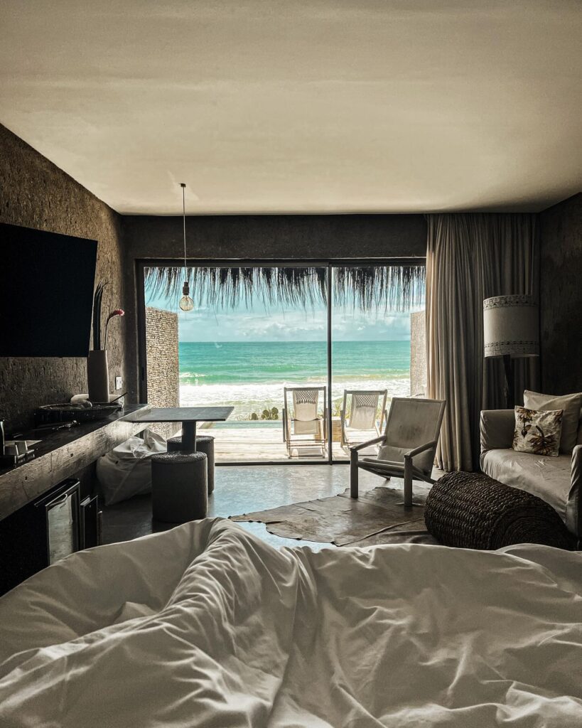 Quarto de resort Kenoa com vista para praia e decoração moderna