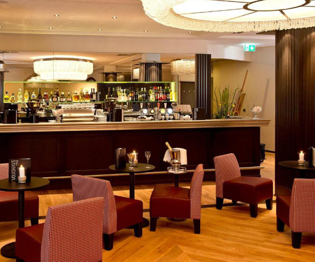 Bar Antika no The Best Western Plus Hotel Bern, interior moderno com móveis vermelhos e iluminação sofisticada.