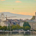 Genebra suiça: paisagem urbana com lago, montanhas e Jet d’Eau iluminado.