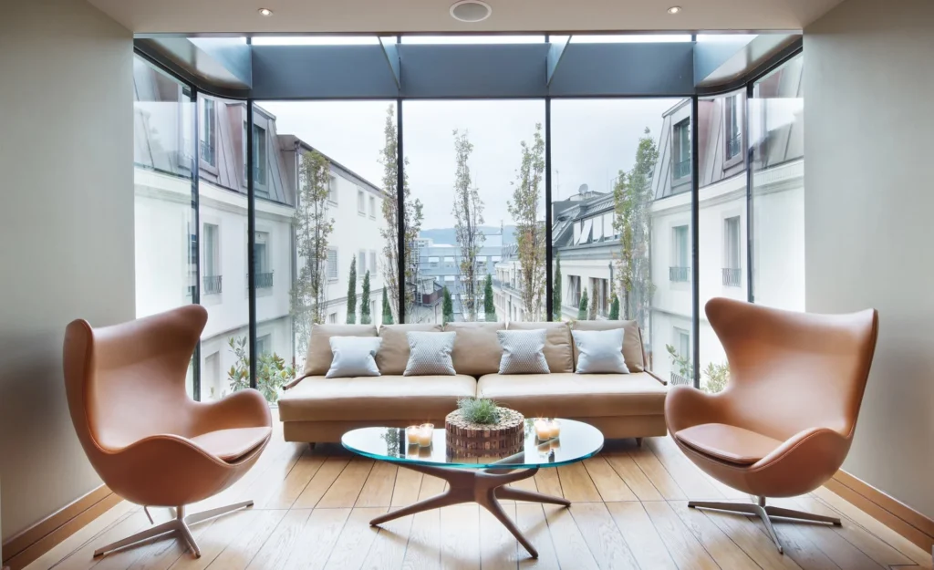 Sala de estar moderna no Four Seasons Genebra com móveis de couro e grandes janelas