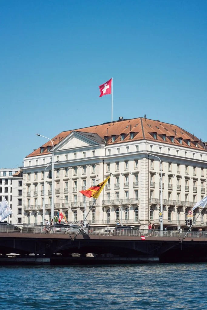 Four Seasons Hotel des Bergues Genebra, edifício neoclássico com bandeira suíça, vista do lago
