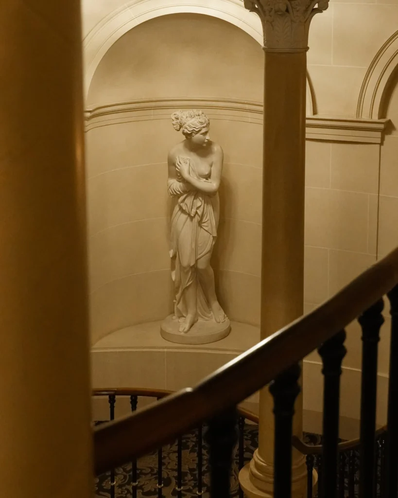 Escadaria de mármore no Four Seasons Genebra com estátua clássica