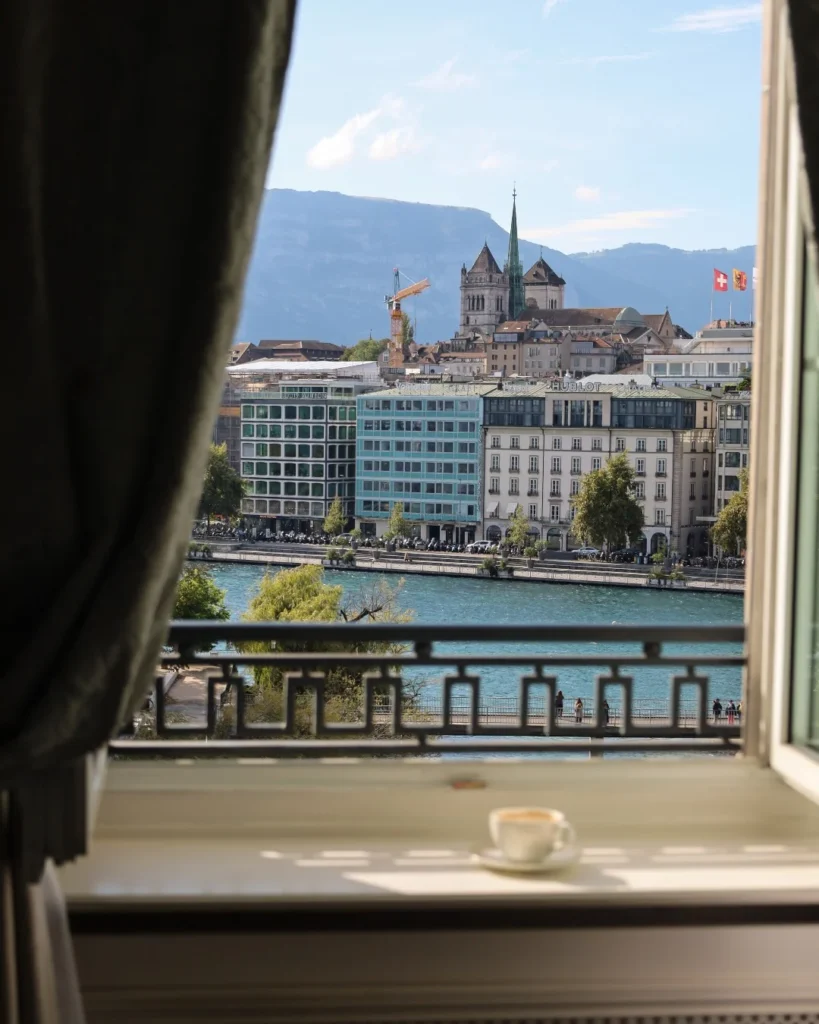 Vista panorâmica do Rio Ródano e Genebra a partir do Four Seasons Genebra, com uma xícara de café em um parapeito