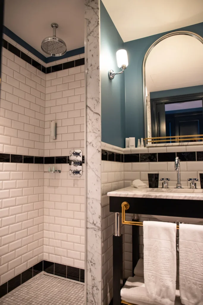 Banheiro moderno do Hotel Longemalle em Genebra com azulejos brancos e chuveiro de chuva