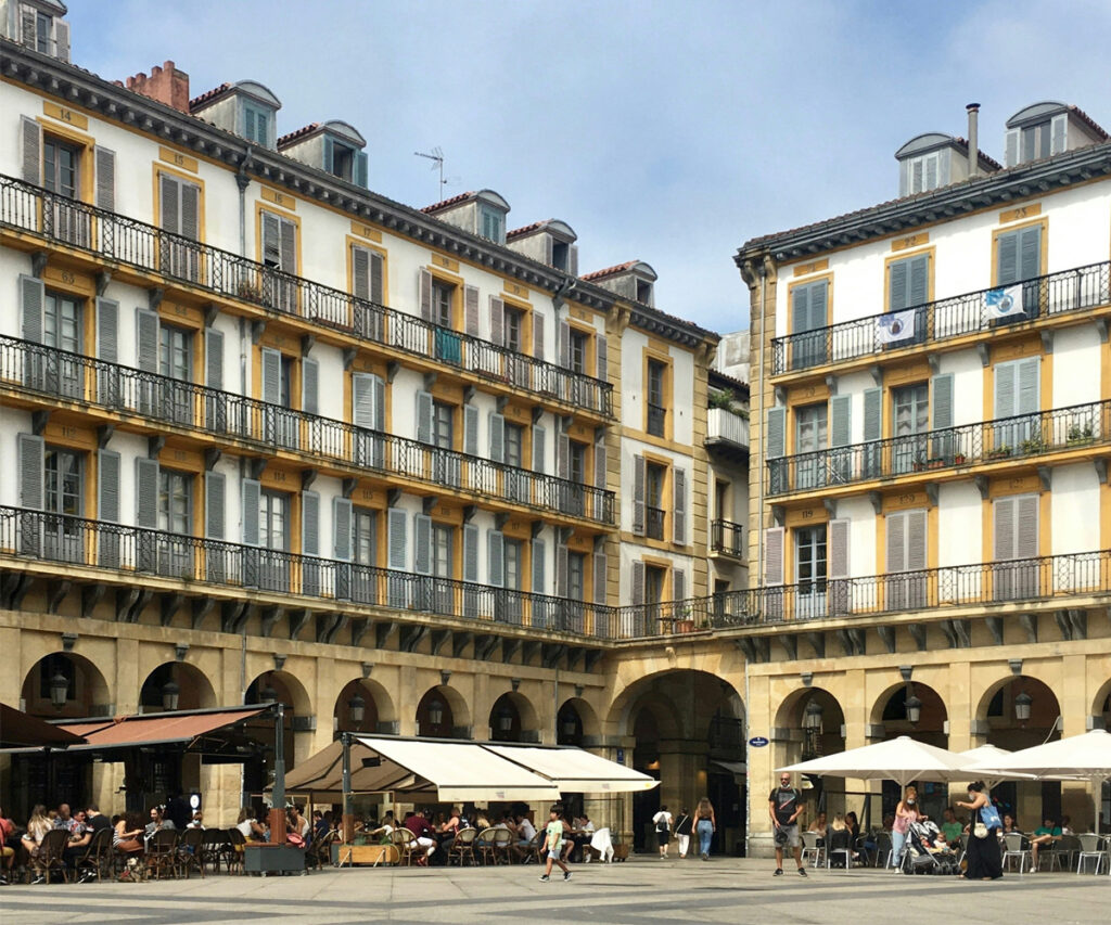 Praça da Constituição em San Sebastián, Espanha, com edifícios históricos e bares de pintxos