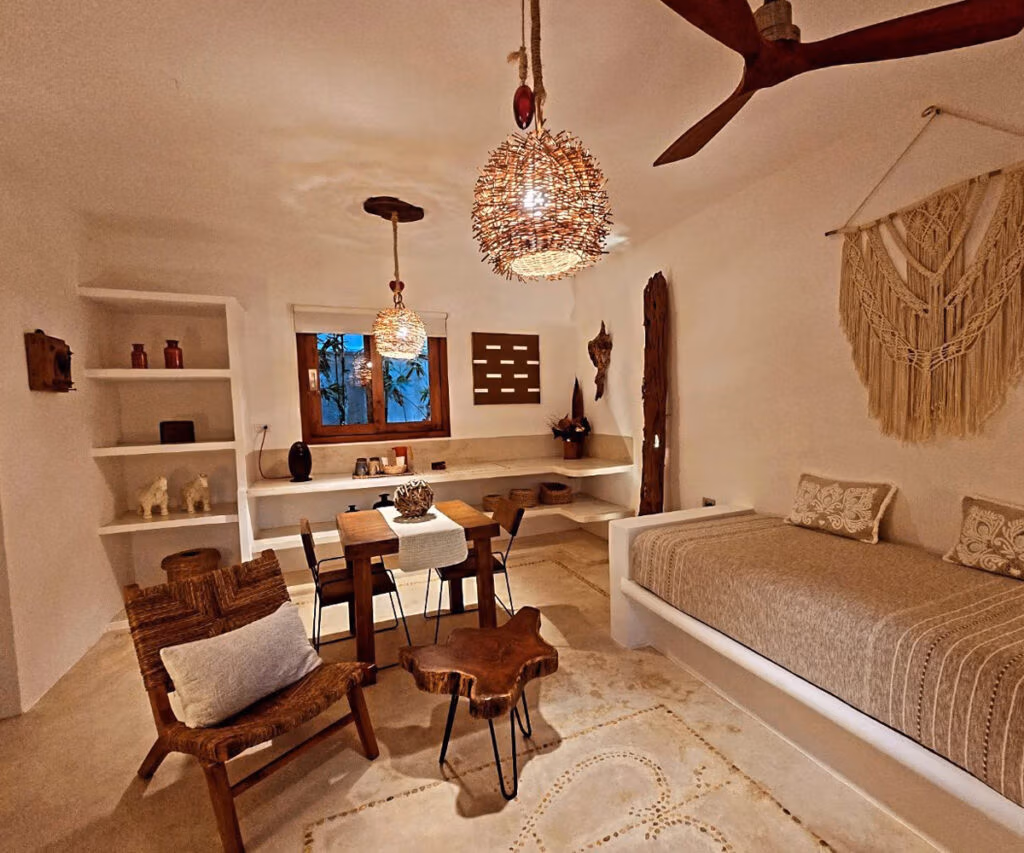 Sala charmosa de boutique hotel holbox com decoração boho, luzes pendentes e detalhes rústicos, ideal para relaxar em Holbox