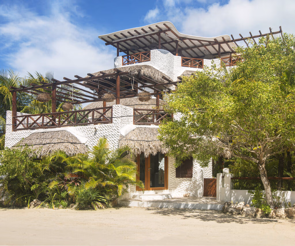 Boutique hotel Holbox: fachada charmosa com arquitetura tropical e thatch, detalhes em madeira e vegetação exuberante