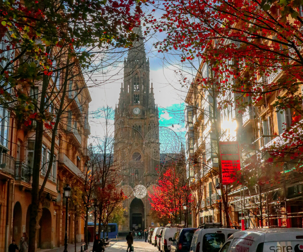 Catedral Barcelona iluminada, rua decorada natalina com luzes e árvores vermelhas, festiva e charmosa