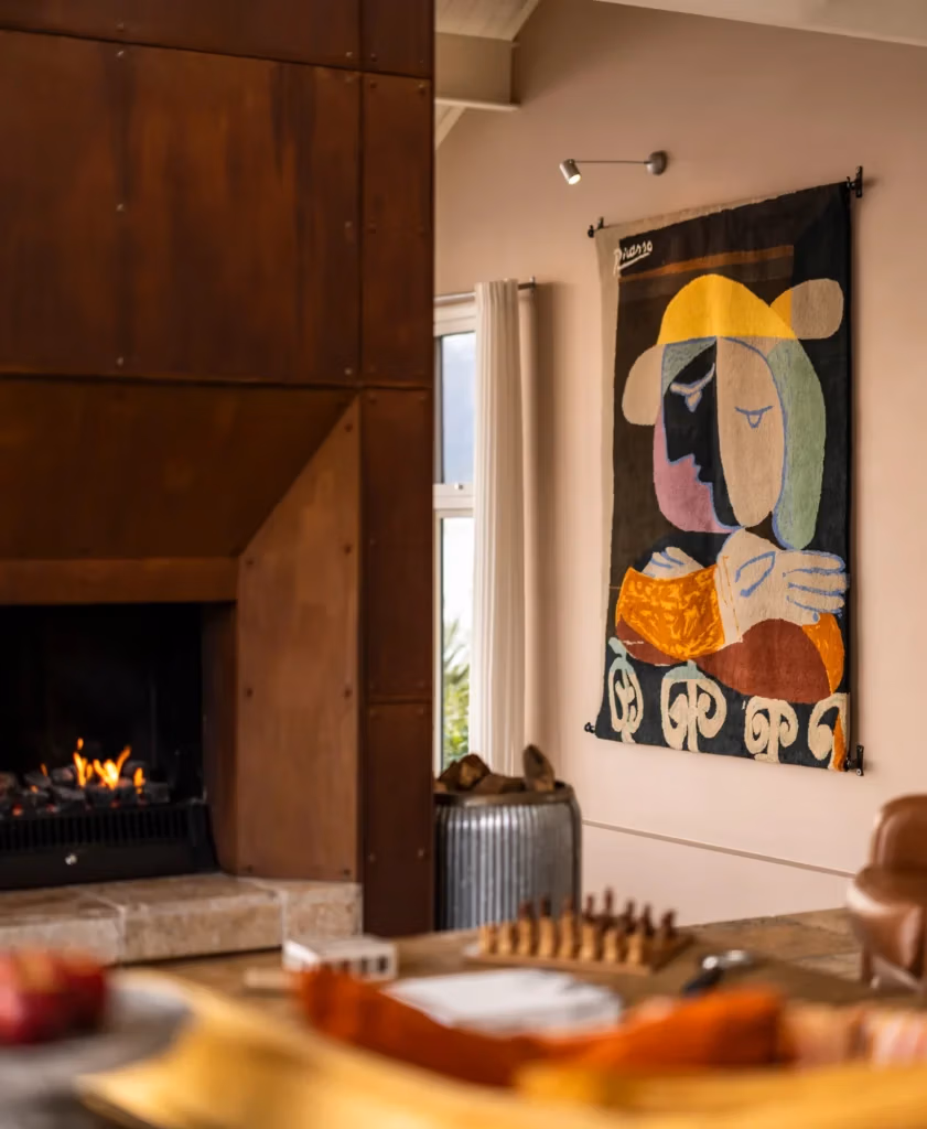 Viagem para Nova Zelândia: decoração acolhedora com arte abstrata e lareira, estilo boho-chique em ambiente rústico-moderno