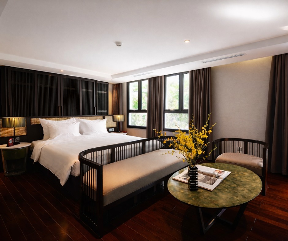 Suíte luxuosa com design oriental moderno, madeira escura e detalhes em mármore verde, ideal para quem busca os melhores hoteis em hanoi.