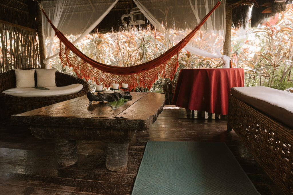 Área de descanso rústica com rede e mobiliário em madeira, opção de charme entre hoteis em são miguel do gostoso.